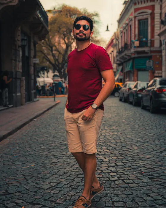 Arnavut kaldırımında bordo tişört ve bej şortlu kombin