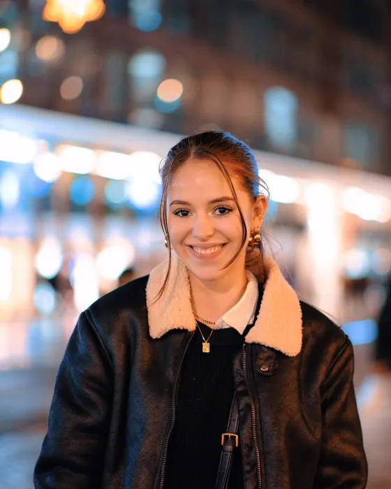 Gece şehir ışıklarında deri ceketli gülümseyen alıcı